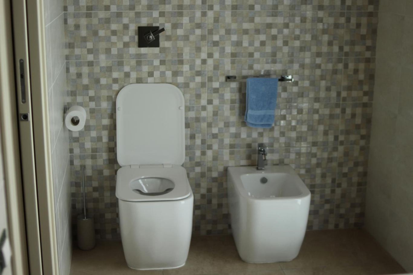 Il bagno rivestito in mosaico, con il water e il bidet.