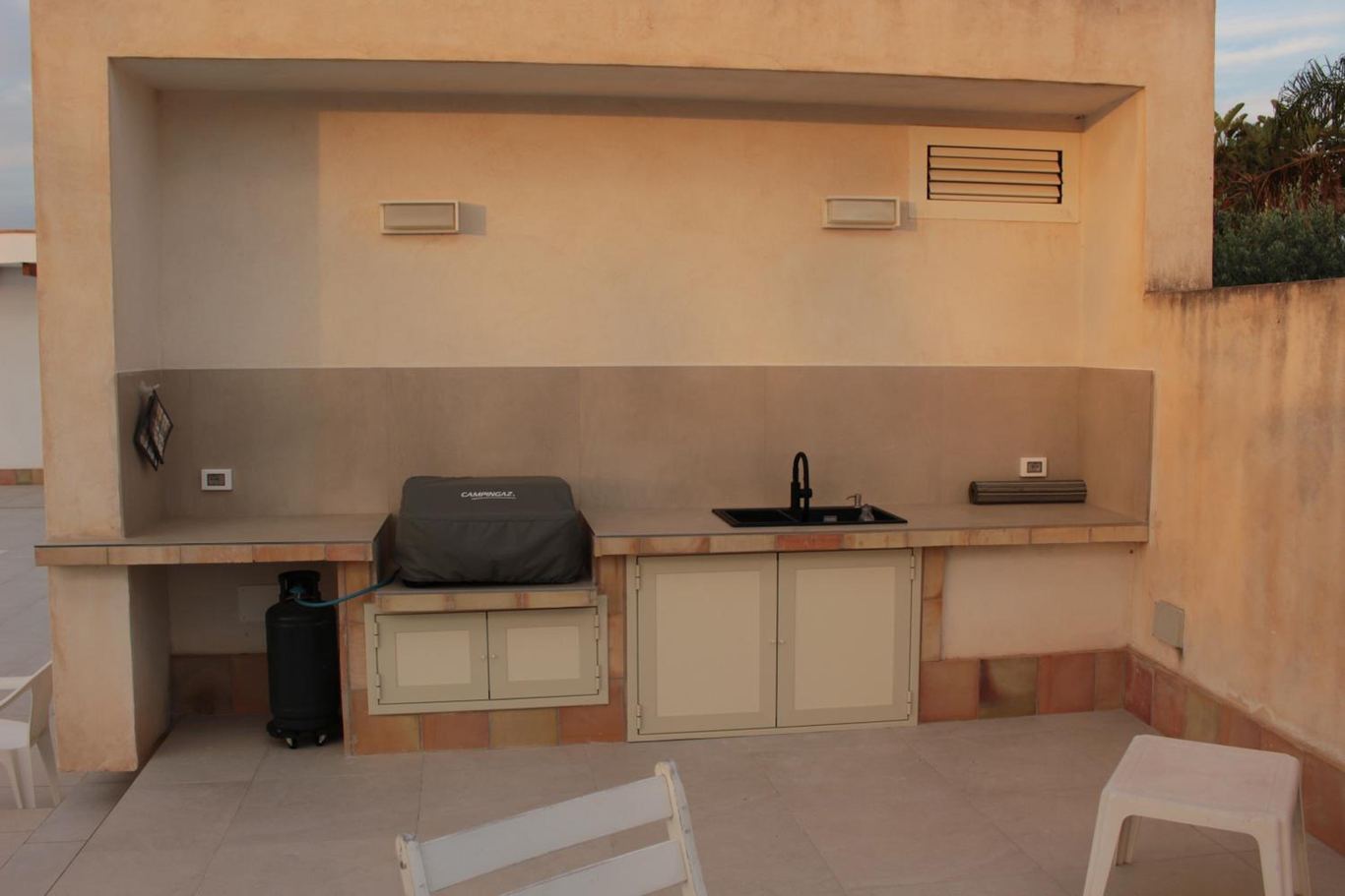 L'angolo della cucina esterna con il barbecue a gas e il piano di lavoro.